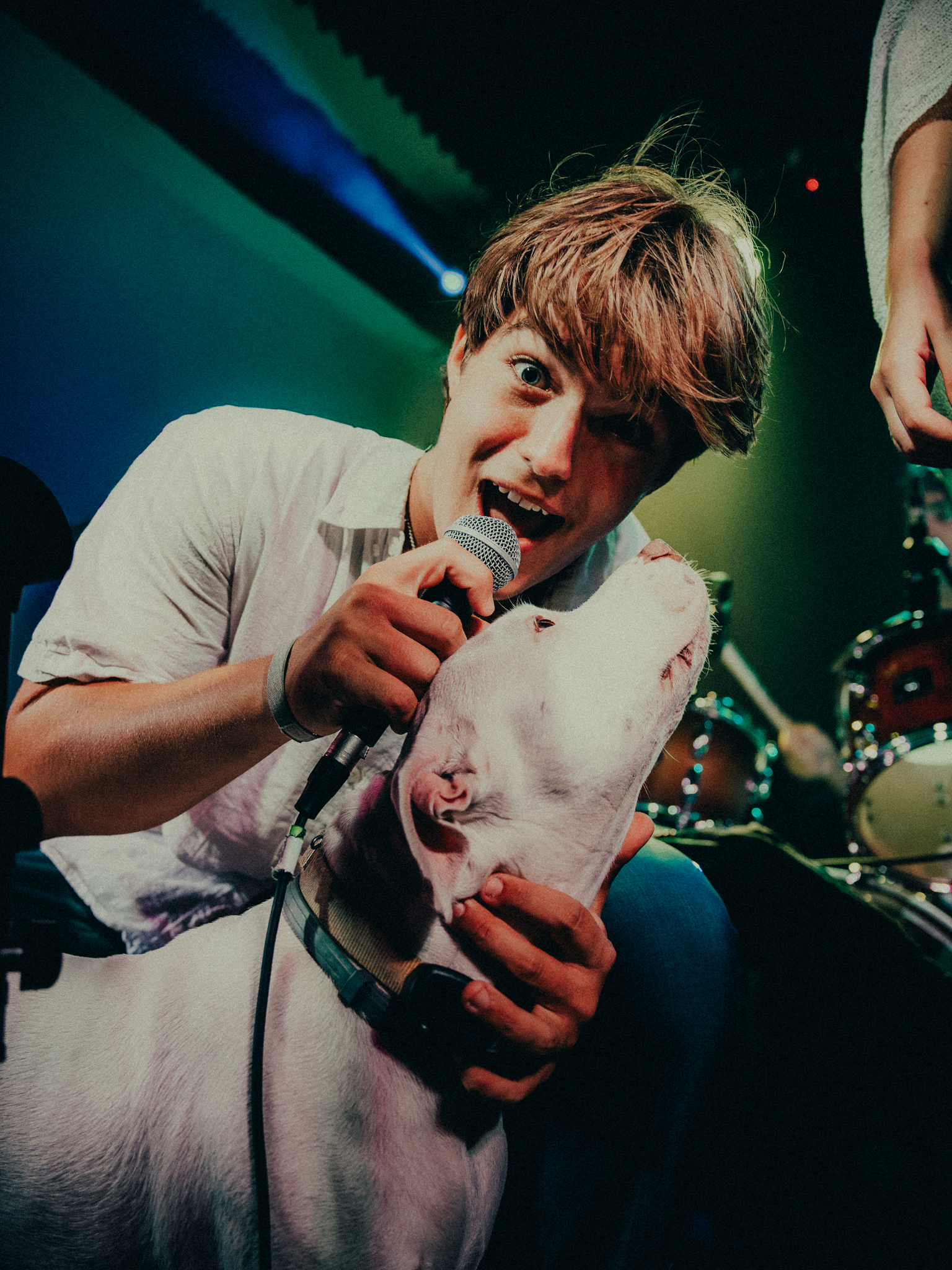 Singer sharing the microphone with a dog onstage