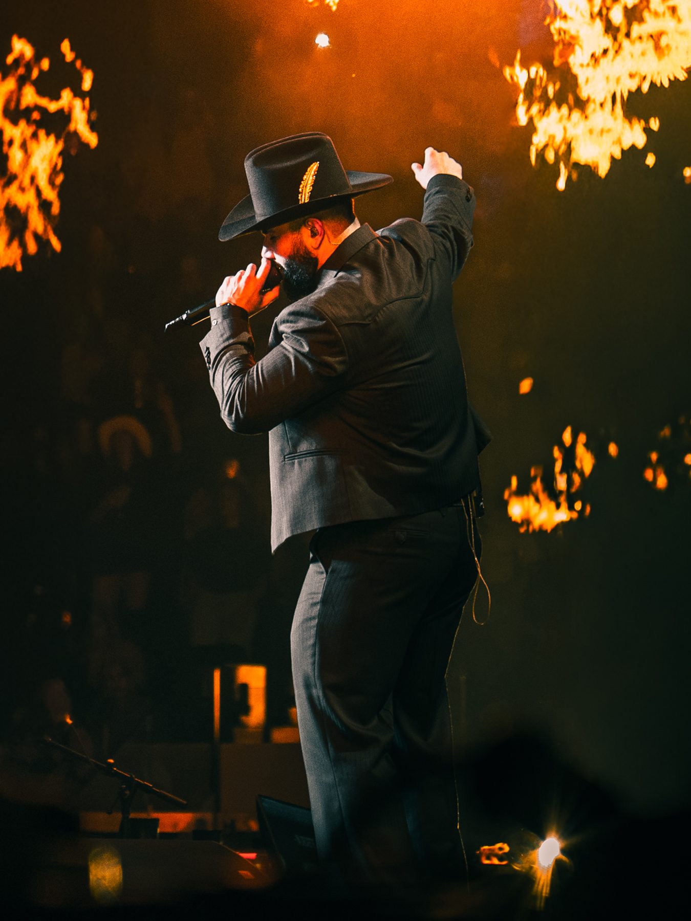 Singer in a black hat backlit by haze