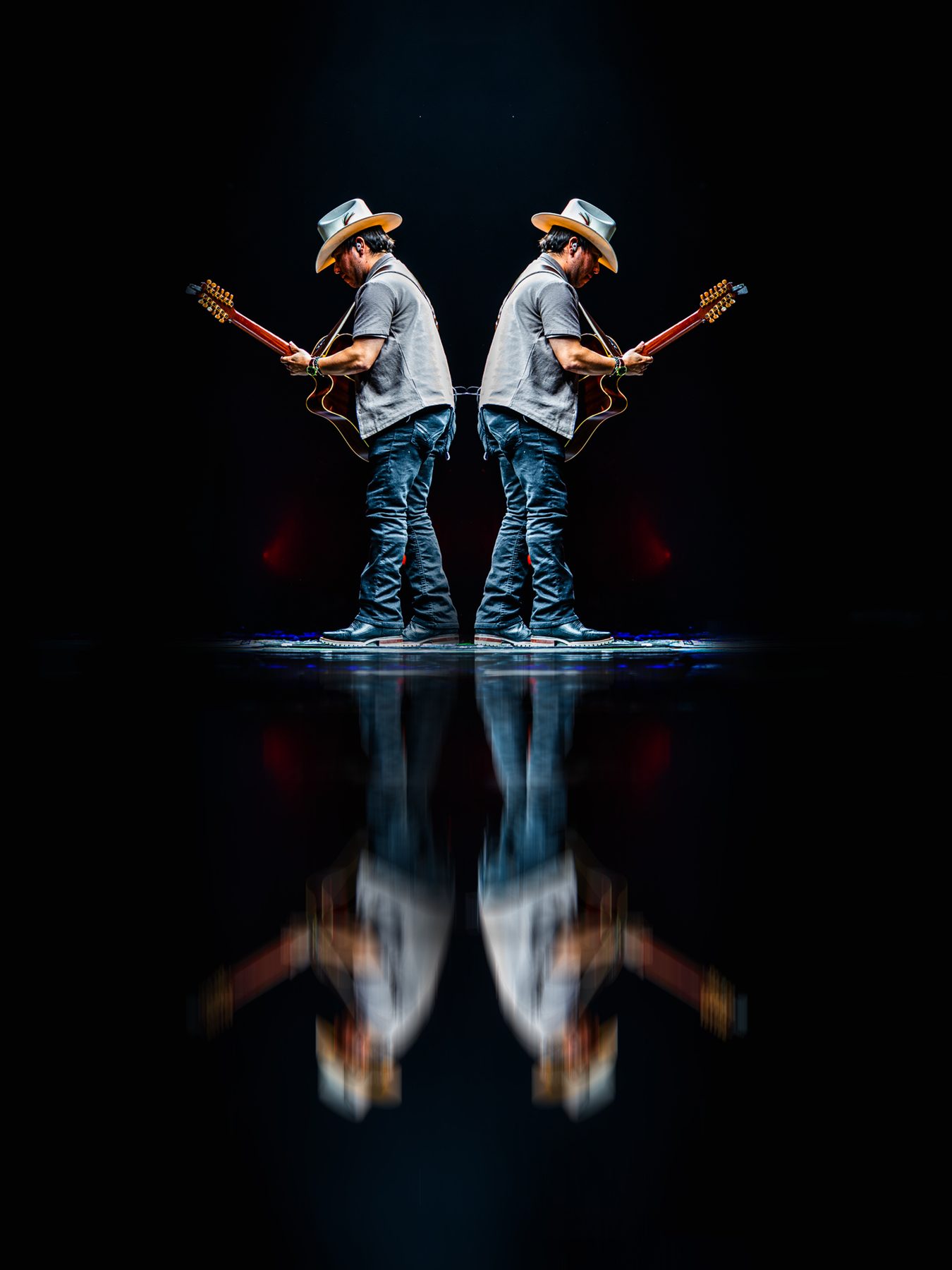 Guitarist mirrored on a reflective stage