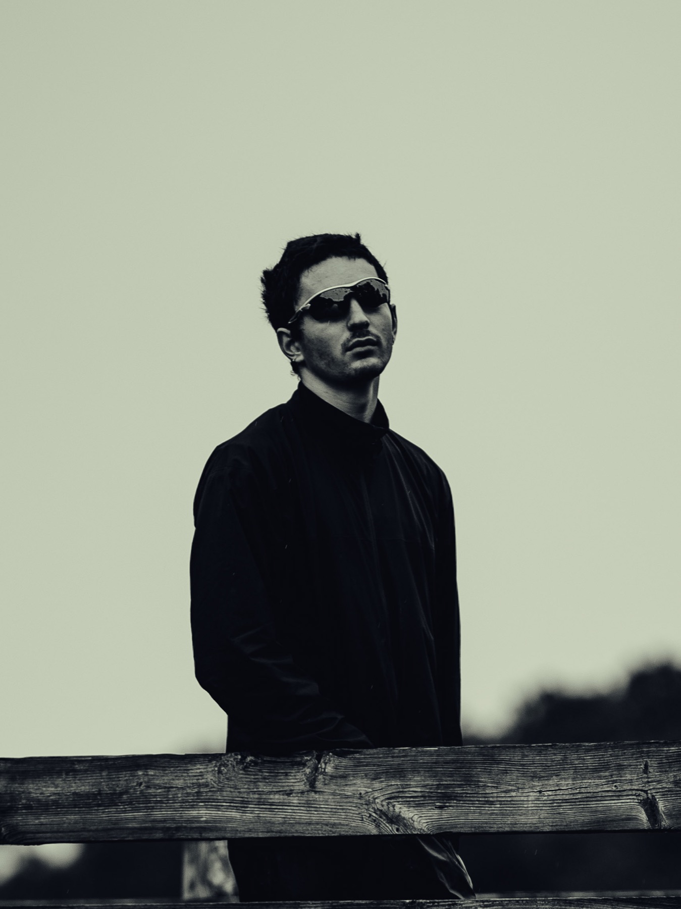 Portrait in sunglasses behind a wooden fence
