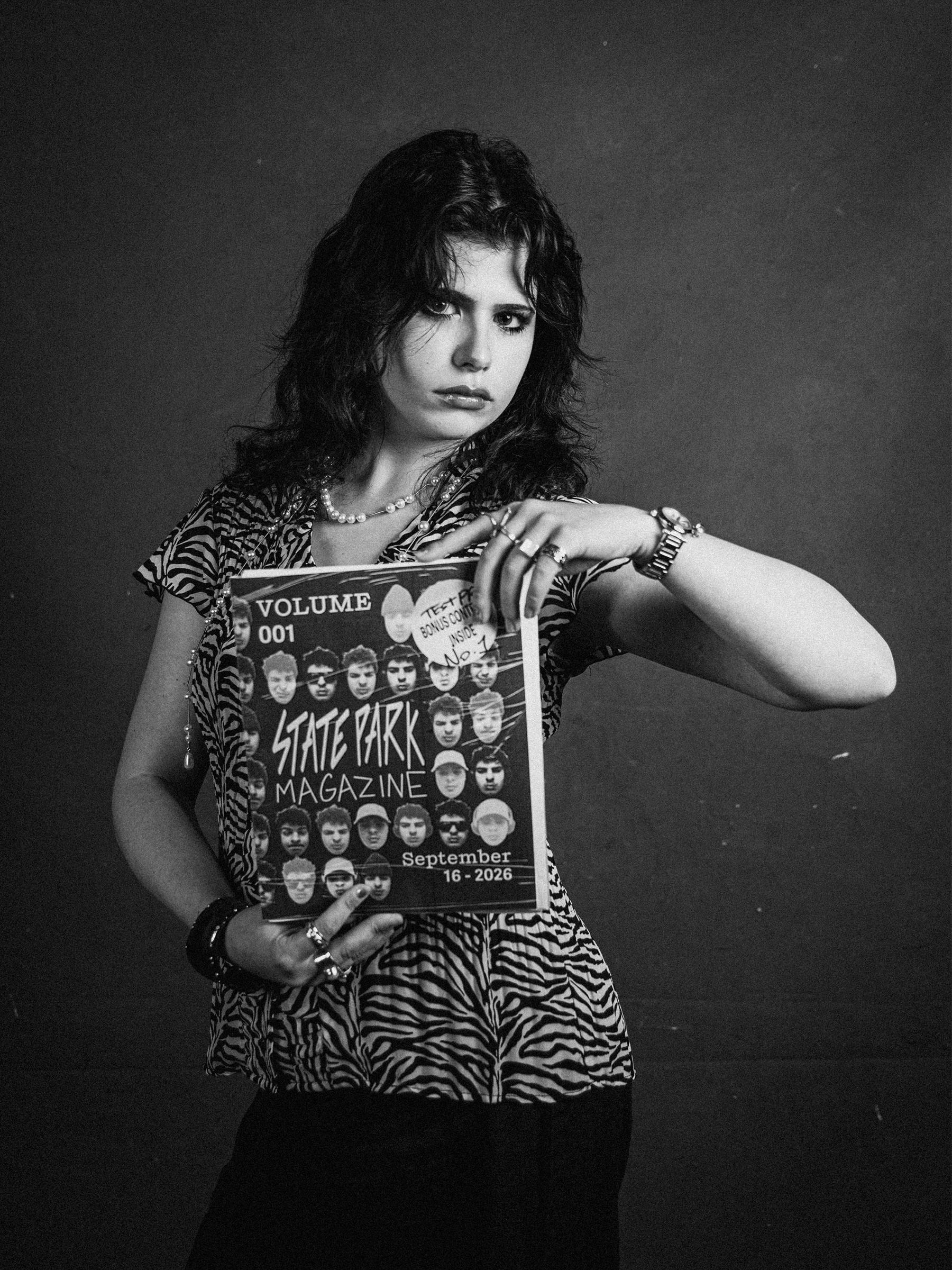 Black-and-white studio portrait holding State Park Magazine
